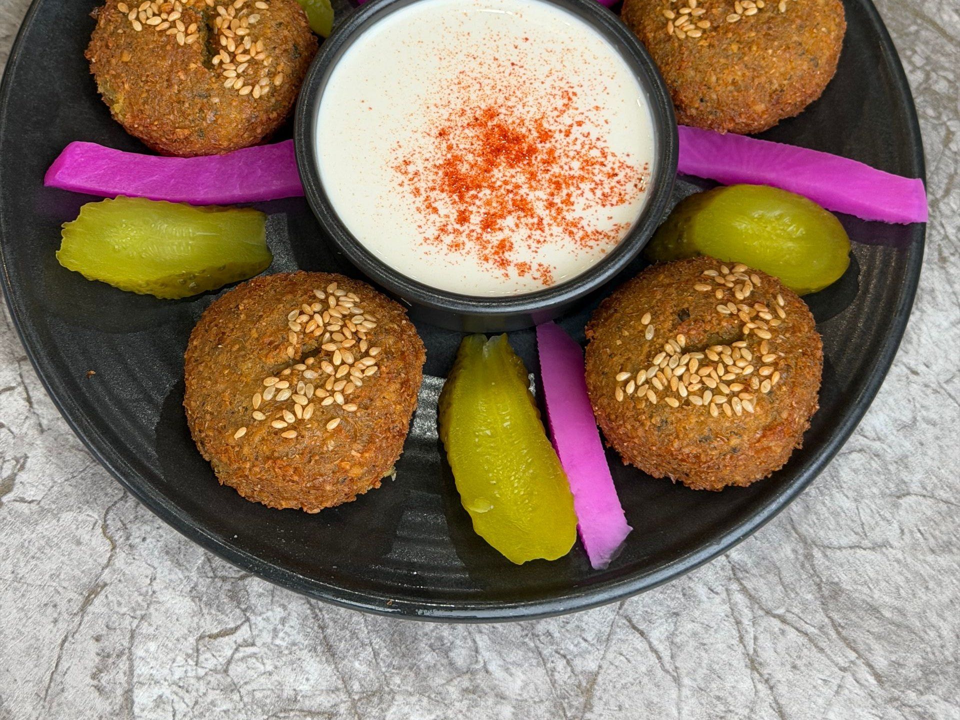 Teller mit Falafel, eingelegtem Gemüse und Sesamsoße